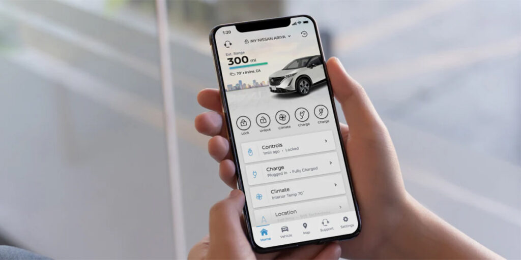 A person holding a phone showing the MyNissan App.