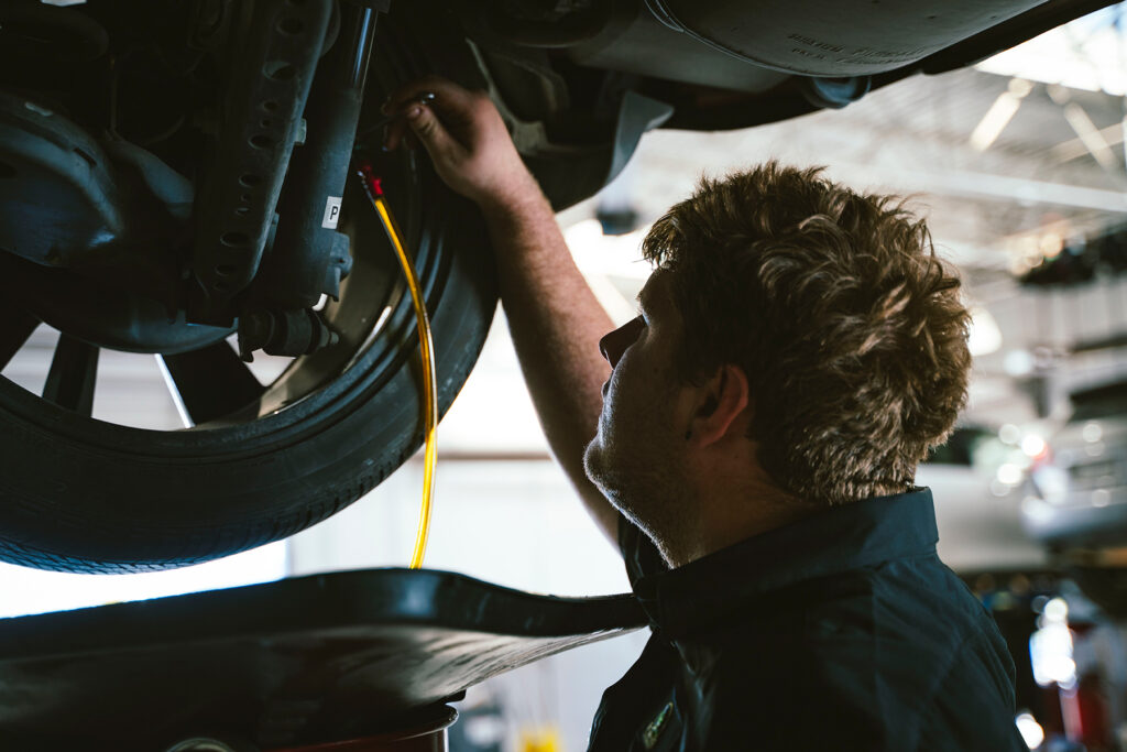 A service technician inspecting tires at McGavock Nissan of Lubbock.