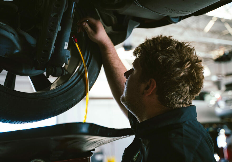 A service technician inspecting tires at McGavock Nissan of Lubbock.